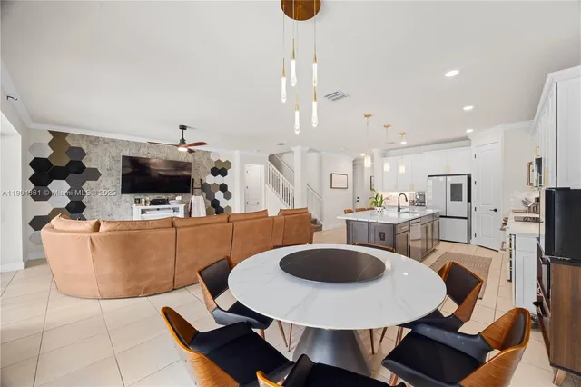 a living room with furniture a flat screen tv and kitchen view
