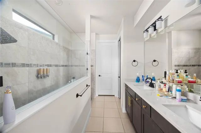 a bathroom with a double vanity sink a mirror and a shower