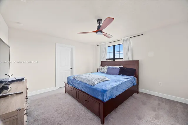 a bedroom with a bed a chandelier and dresser