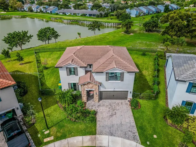 an aerial view of a house with a garden and lake view