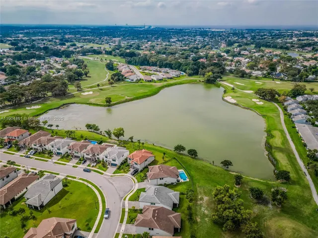 an aerial view of a house with a garden and lake view