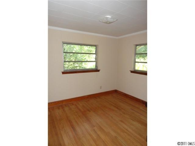 1300 Shearers Road Mooresville, NC 28115 - Photo 5 of 7 a view of an empty room with wooden floor and a window