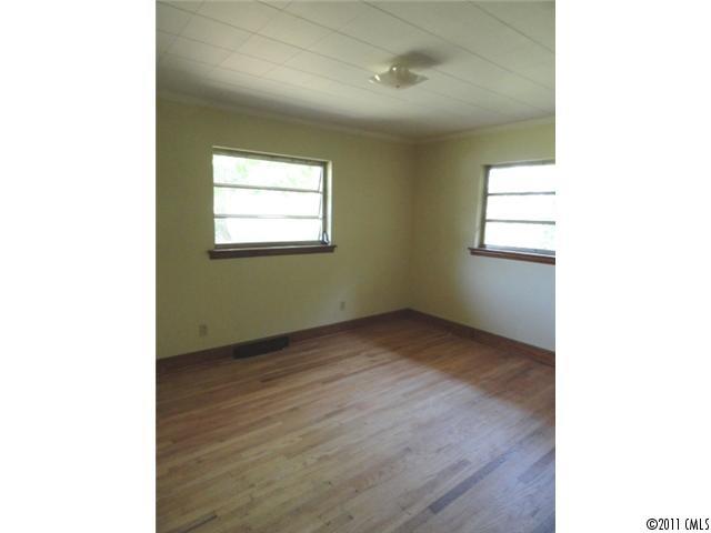 1300 Shearers Road Mooresville, NC 28115 - Photo 6 of 7 a view of an empty room with wooden floor and a window