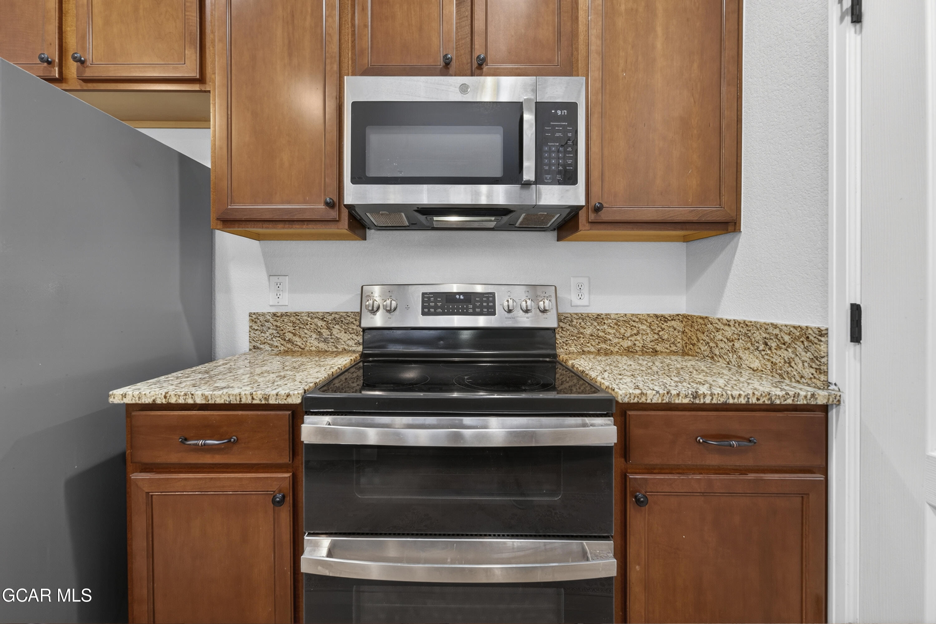 158 Village Road Granby, CO 80446 - Photo 5 of 46 a kitchen with granite countertop a stove top oven microwave and cabinets