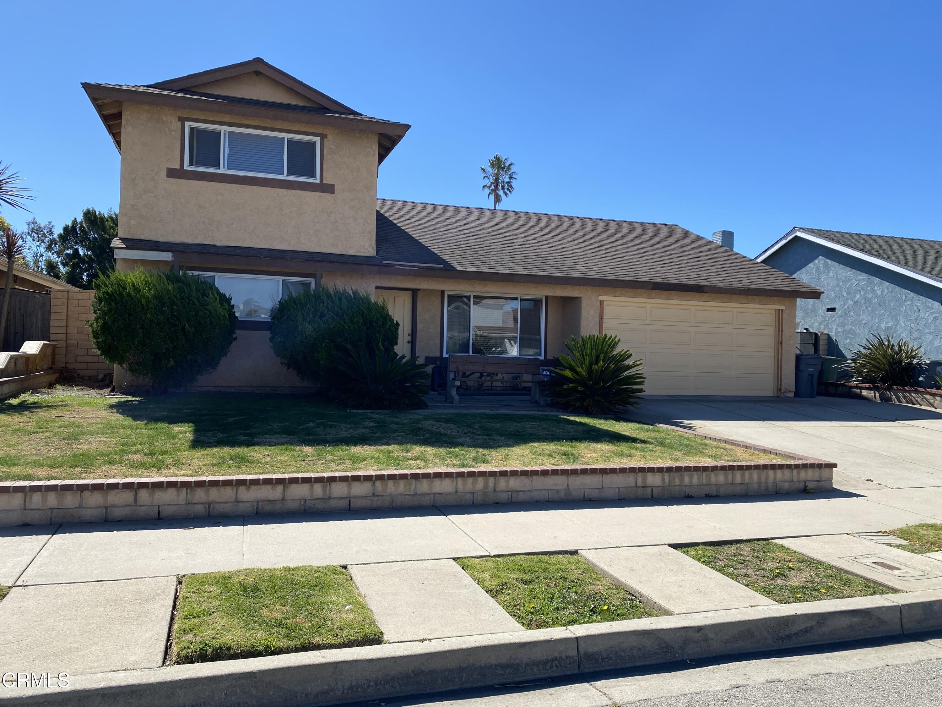 a front view of a house with a yard and potted plants