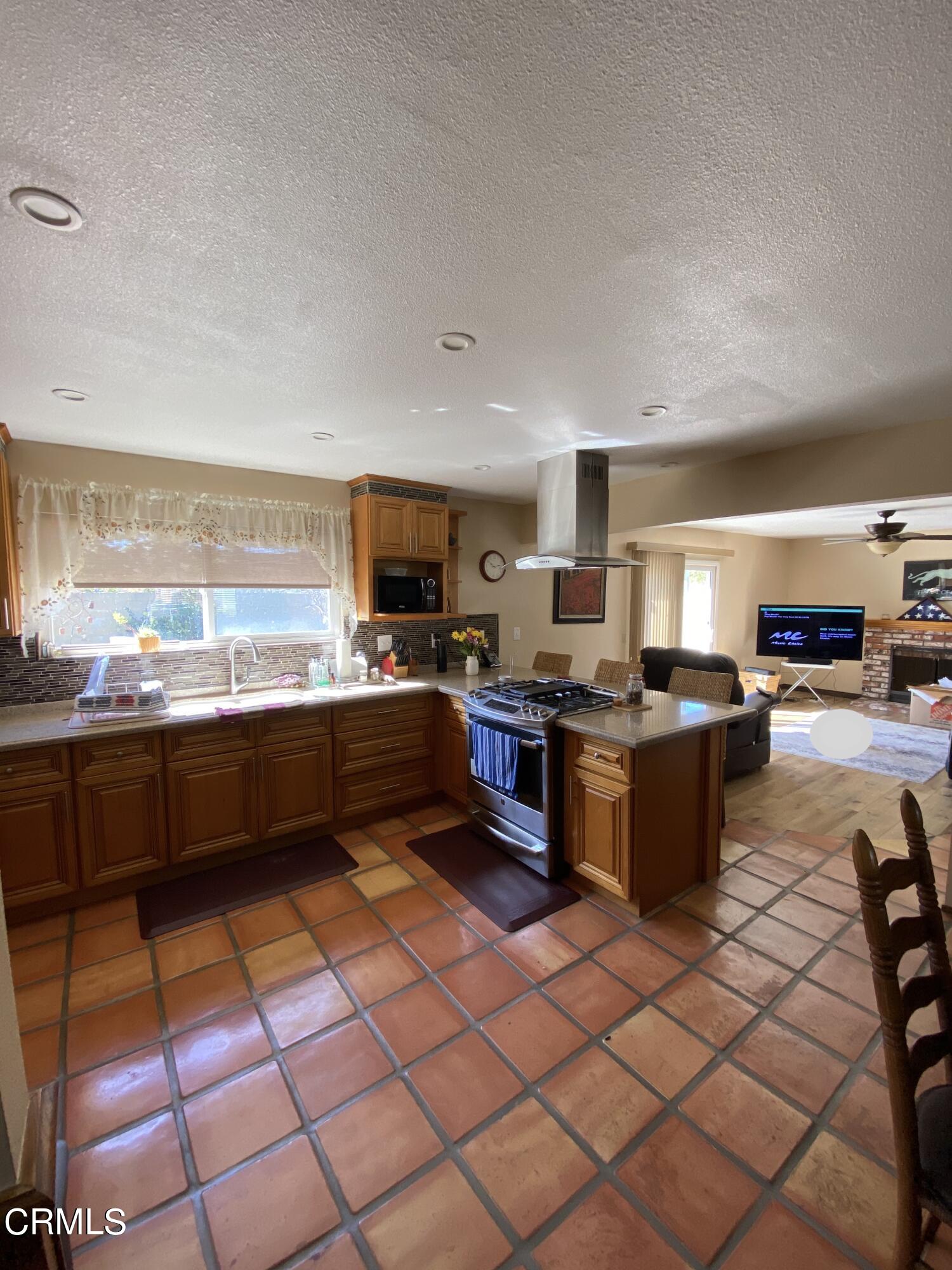 3470 Taffrail Lane Oxnard, CA 93035 - Photo 6 of 15 a kitchen with stainless steel appliances kitchen island granite countertop a sink counter space and a view of living room