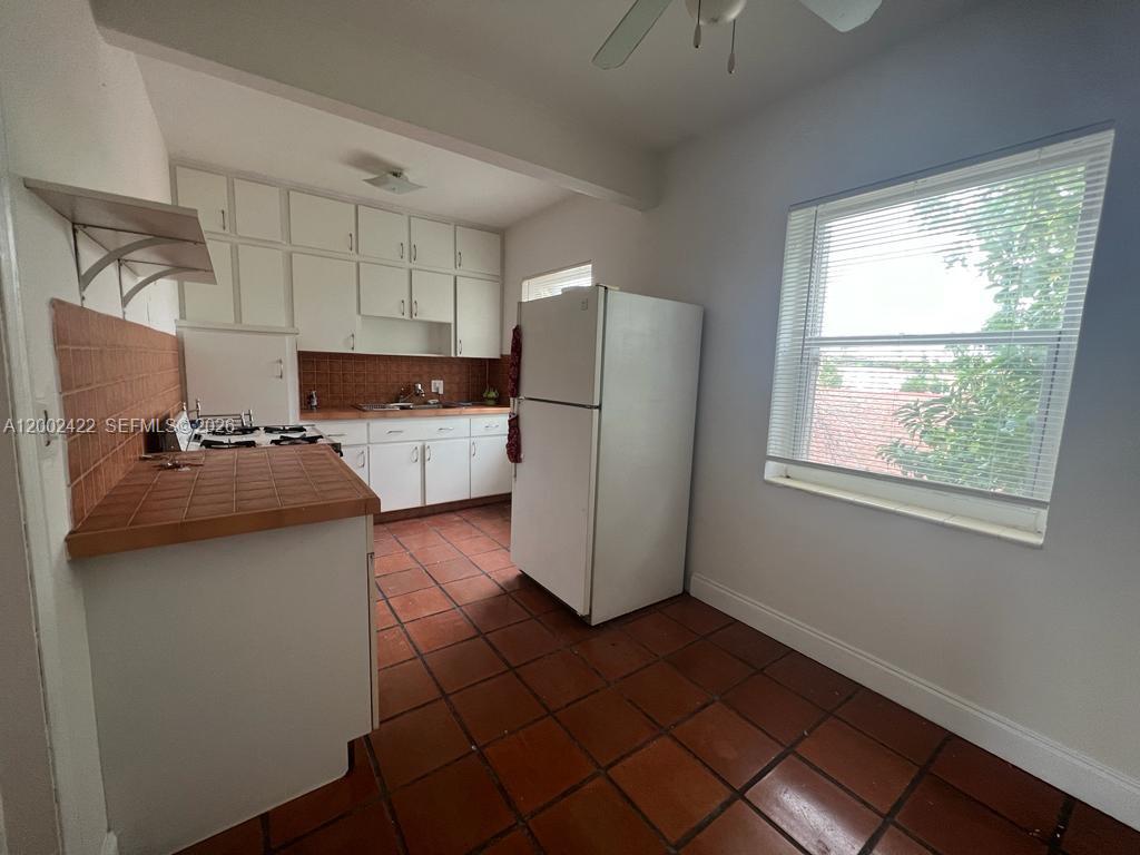 1421 Southwest 37th Avenue, Unit 3 Miami, FL 33145 - Photo 13 of 17 a kitchen with a sink a refrigerator and cabinets