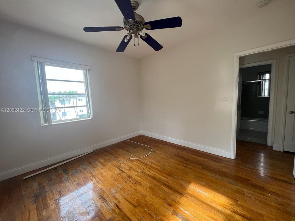 1421 Southwest 37th Avenue, Unit 3 Miami, FL 33145 - Photo 6 of 17 a view of empty room with wooden floor and fan