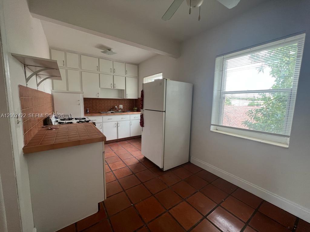 1421 Southwest 37th Avenue, Unit 3 Miami, FL 33145 - Photo 9 of 17 a kitchen with a refrigerator a stove top oven and a window