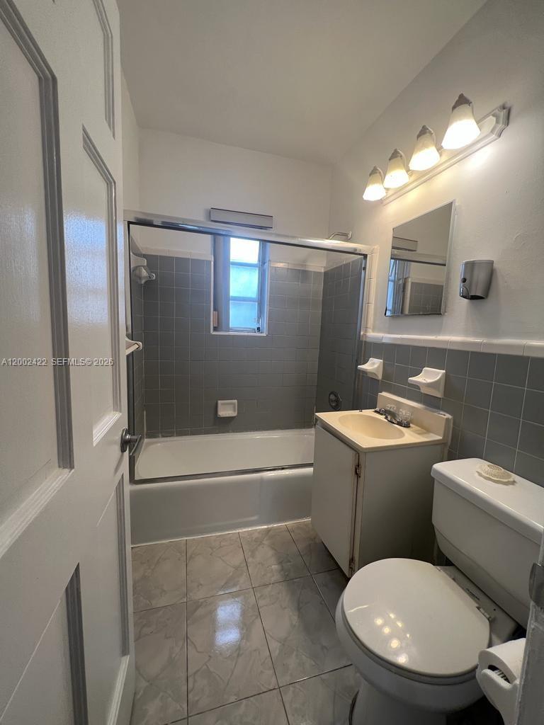 1421 Southwest 37th Avenue, Unit 3 Miami, FL 33145 - Photo 10 of 17 a bathroom with a toilet sink and mirror