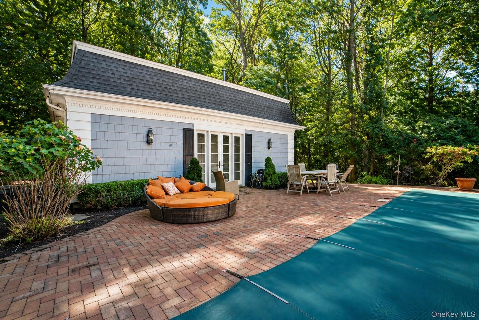 704 Short Beach Road Nissequogue, NY 11780 - Photo 20 of 25 a backyard of a house with table and chairs potted plants and large tree