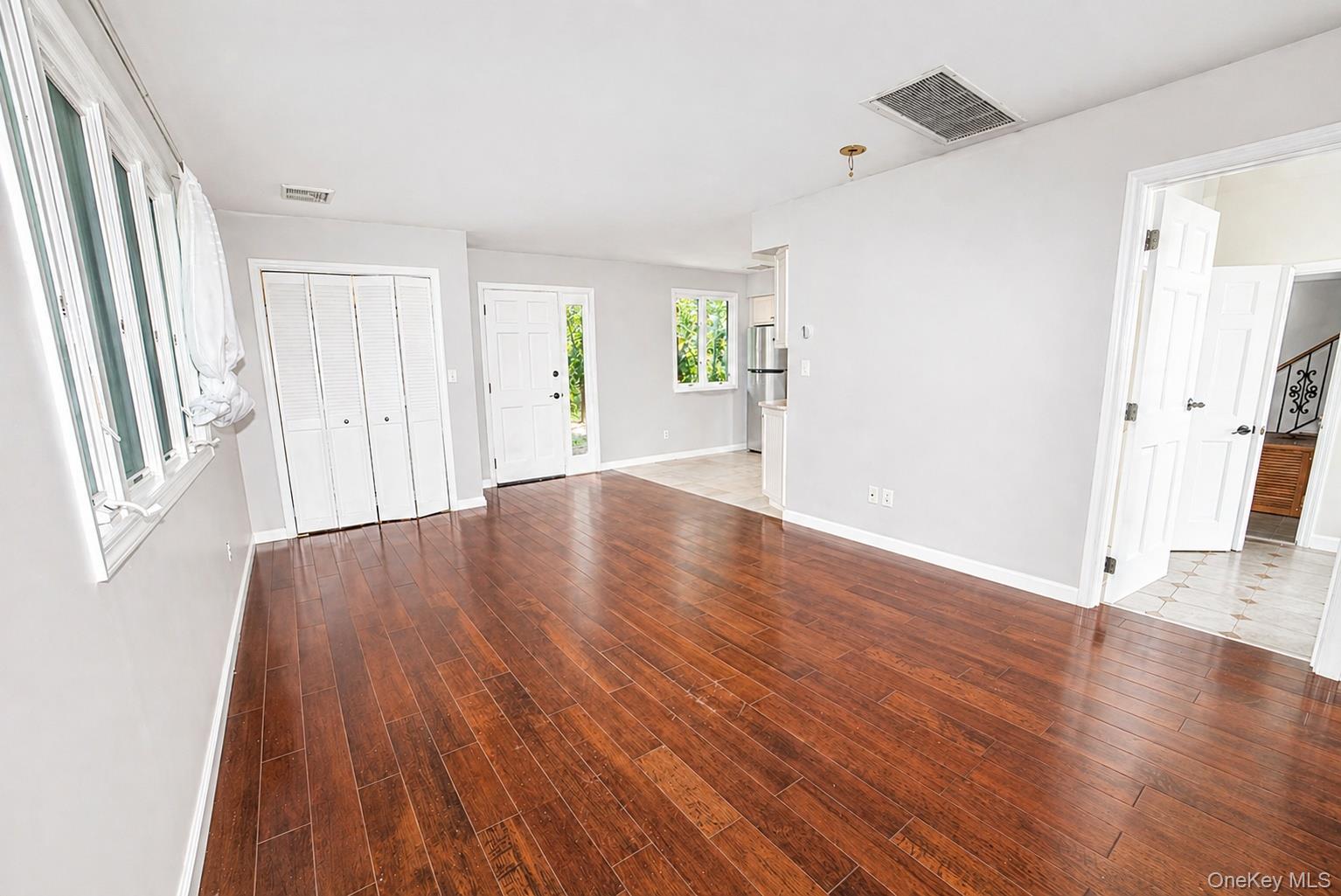 704 Short Beach Road Nissequogue, NY 11780 - Photo 21 of 25 an empty room with wooden floor and windows