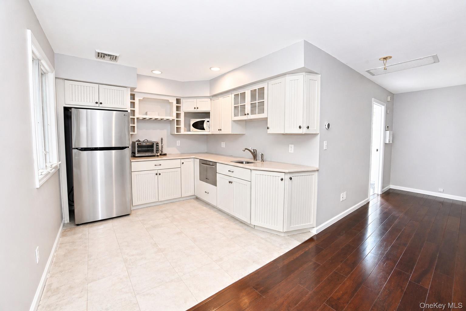 704 Short Beach Road Nissequogue, NY 11780 - Photo 22 of 25 a kitchen with white cabinets and white appliances