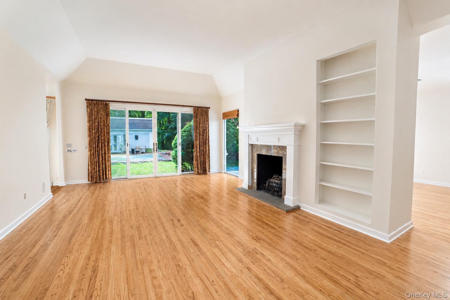 704 Short Beach Road Nissequogue, NY 11780 - Photo 8 of 25 a view of an empty room with wooden floor fireplace and a window