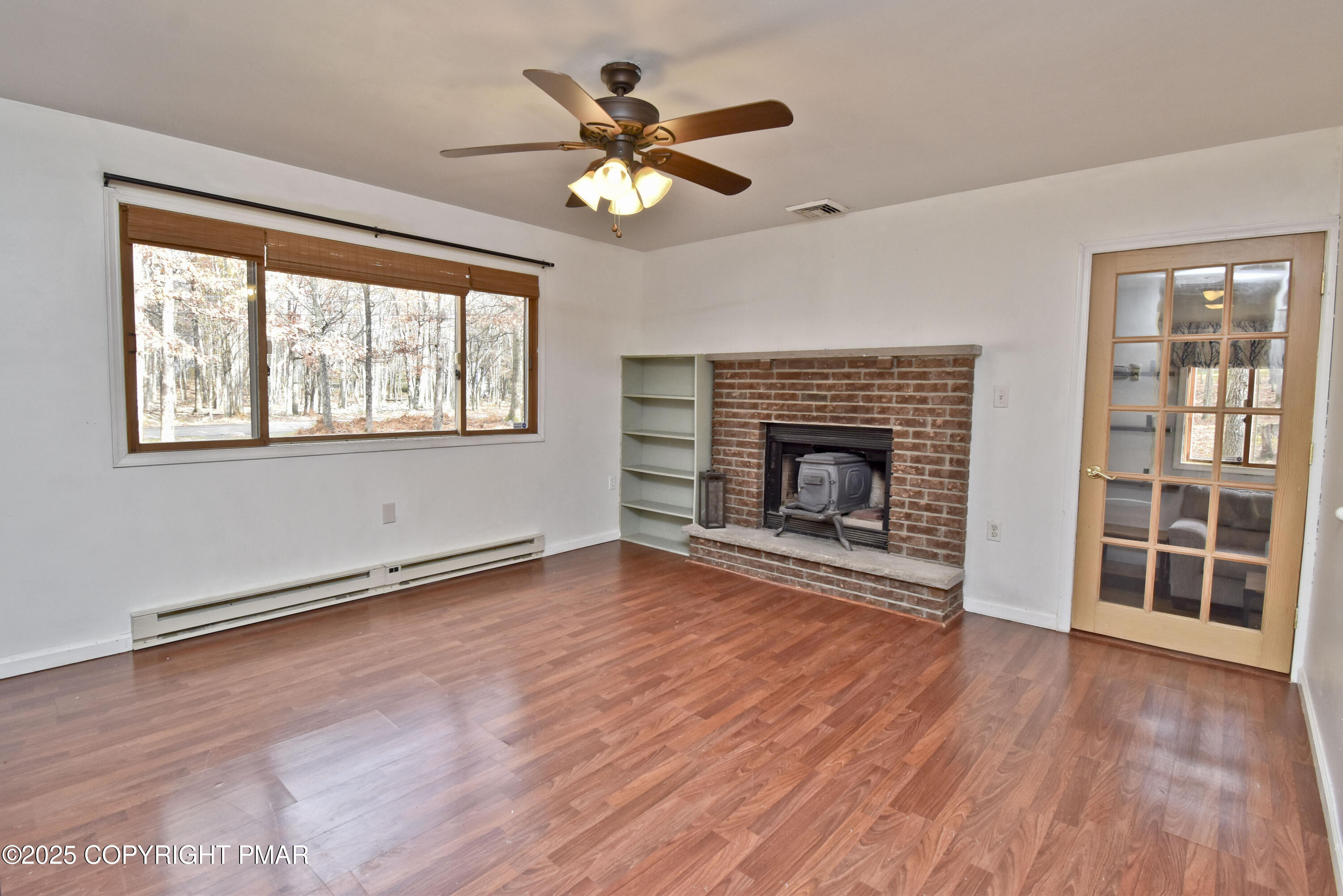 3282 Bluebird Drive Bushkill, PA 18324 - Photo 2 of 36 wooden floor fireplace and windows in an empty room