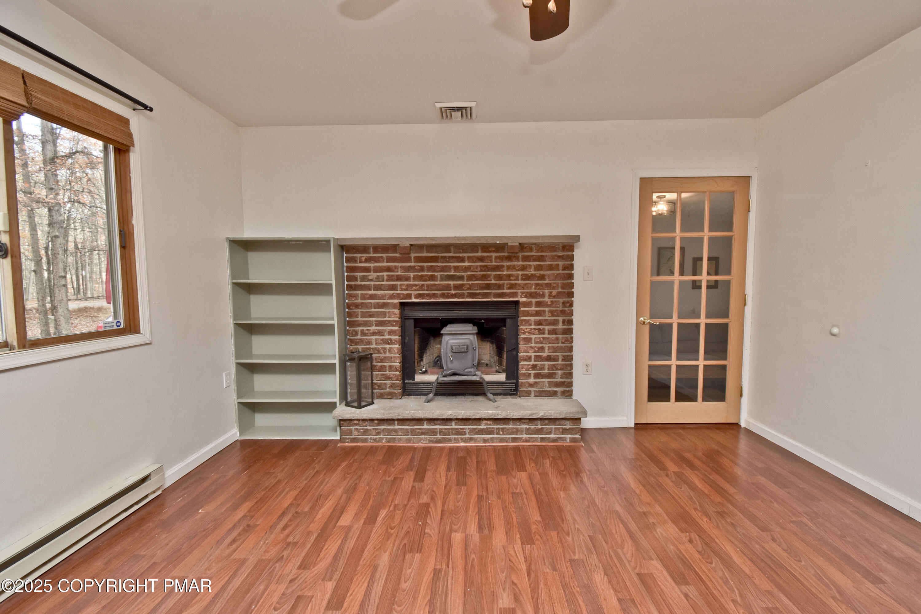 3282 Bluebird Drive Bushkill, PA 18324 - Photo 3 of 36 a view of an empty room with wooden floor fireplace and a window