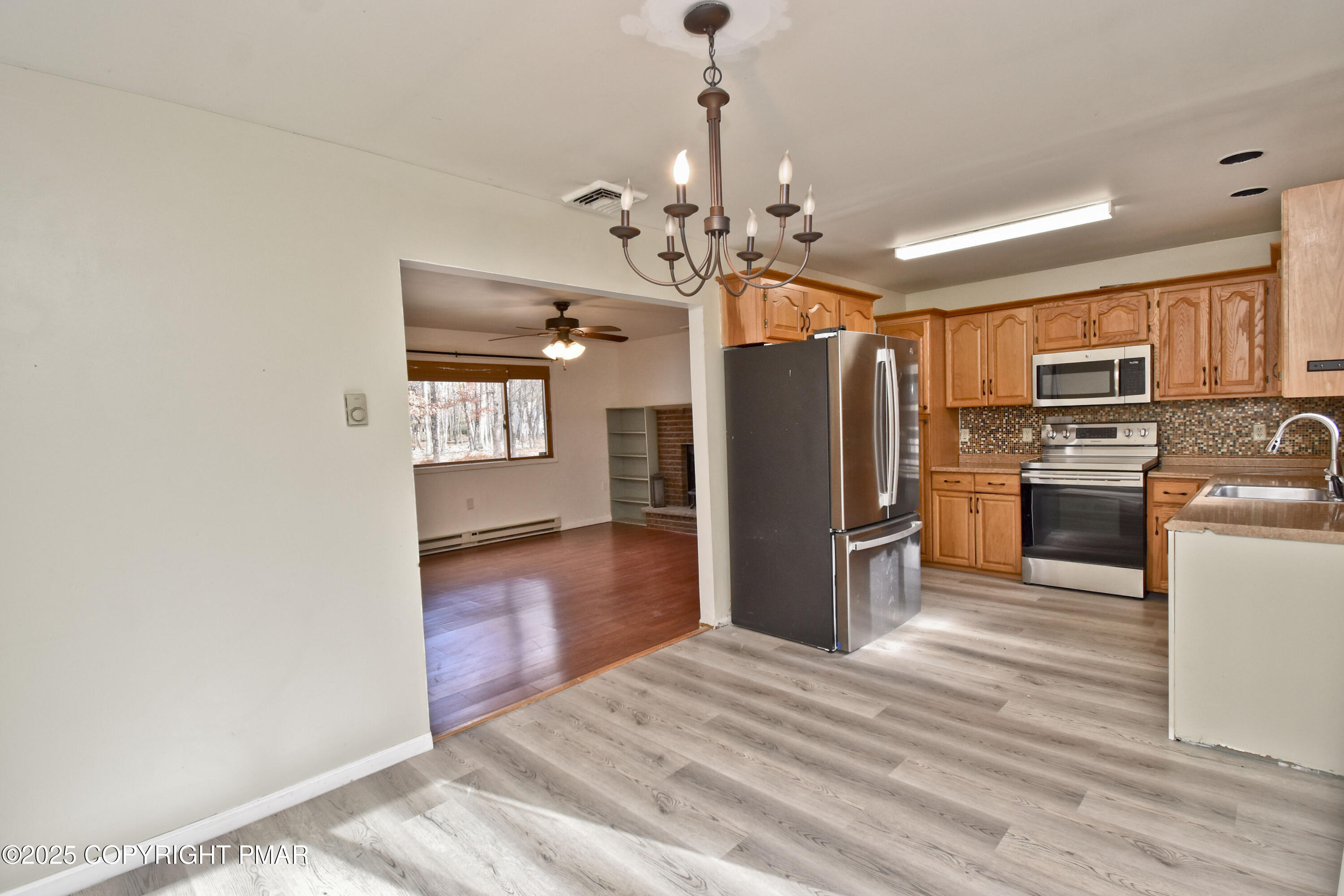 3282 Bluebird Drive Bushkill, PA 18324 - Photo 6 of 36 a kitchen with granite countertop stainless steel appliances a refrigerator and a stove top oven