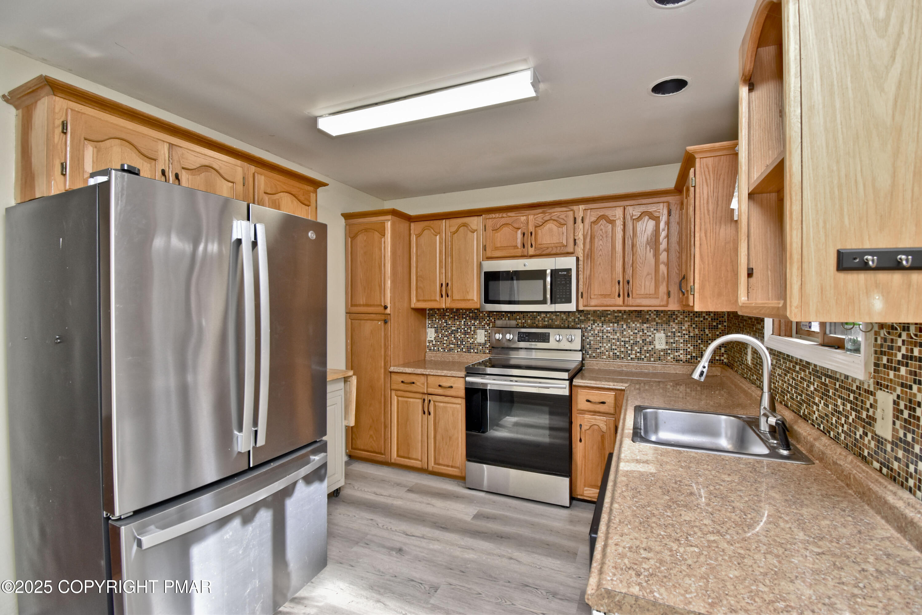 3282 Bluebird Drive Bushkill, PA 18324 - Photo 7 of 36 a kitchen with stainless steel appliances granite countertop a refrigerator stove and sink