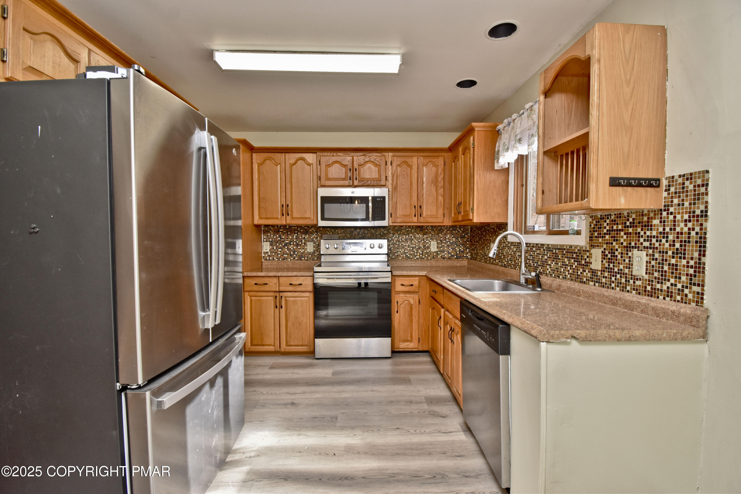 3282 Bluebird Drive Bushkill, PA 18324 - Photo 8 of 36 a kitchen with stainless steel appliances granite countertop a refrigerator and a sink