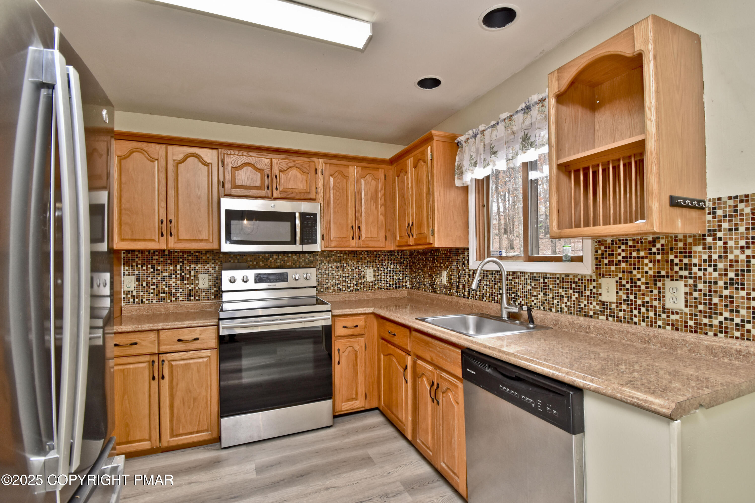 3282 Bluebird Drive Bushkill, PA 18324 - Photo 9 of 36 a kitchen with stainless steel appliances granite countertop a sink and a stove top oven