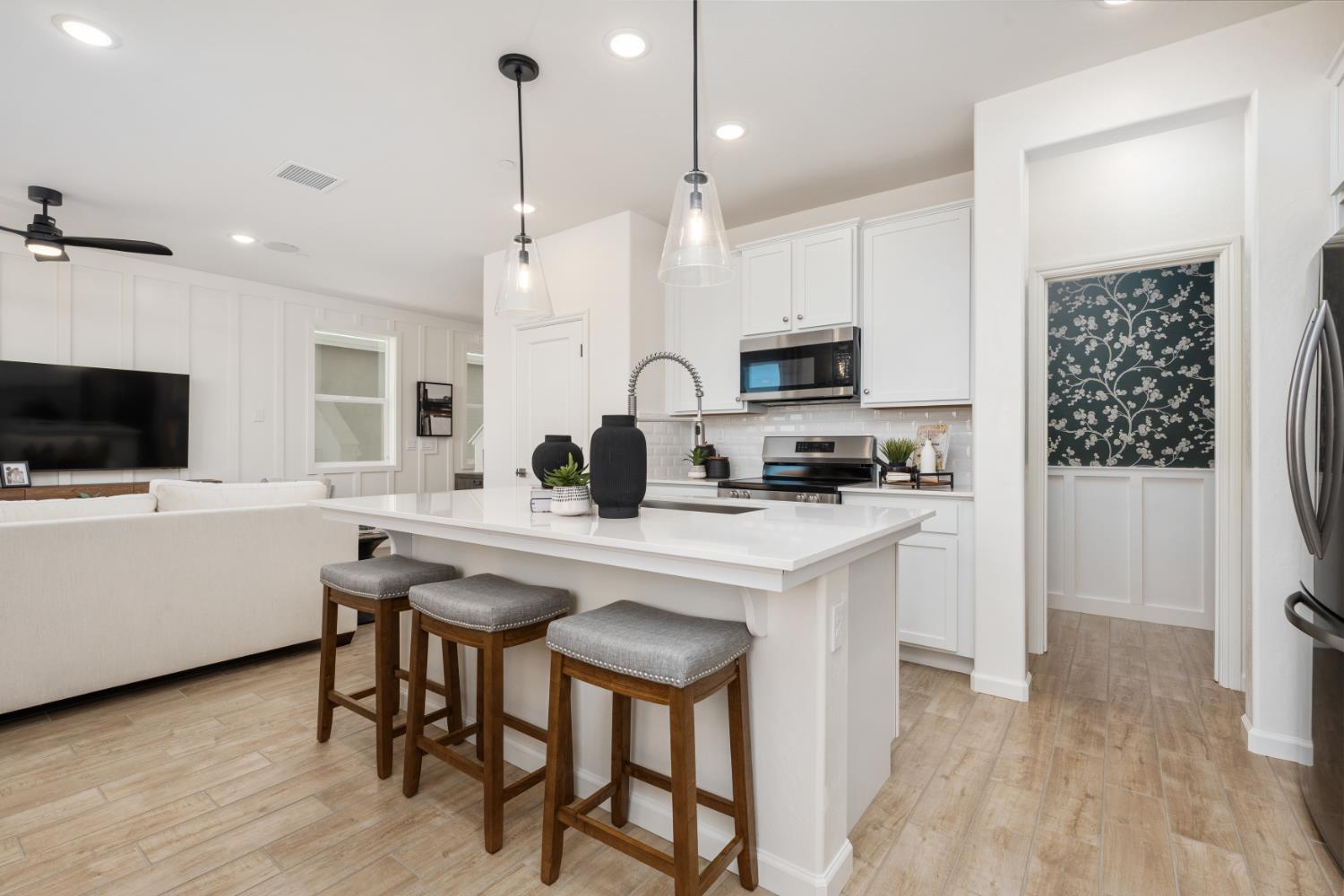 1454 Redbrick Lane Clovis, CA 93619 - Photo 10 of 33 a kitchen with stainless steel appliances a stove a sink a refrigerator a microwave a sink and white cabinets with wooden floor