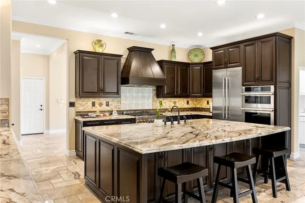 a kitchen with stainless steel appliances granite countertop a stove refrigerator sink and cabinets