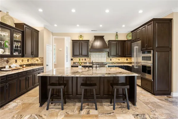a kitchen with stainless steel appliances kitchen island granite countertop a stove and a sink
