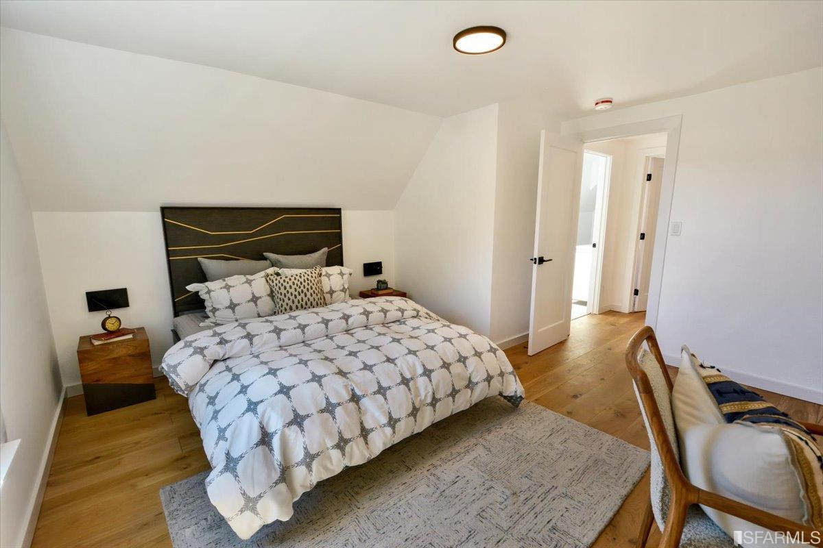 334 Holladay Avenue San Francisco, CA 94110 - Photo 17 of 36 a bedroom with a bed and wooden floor