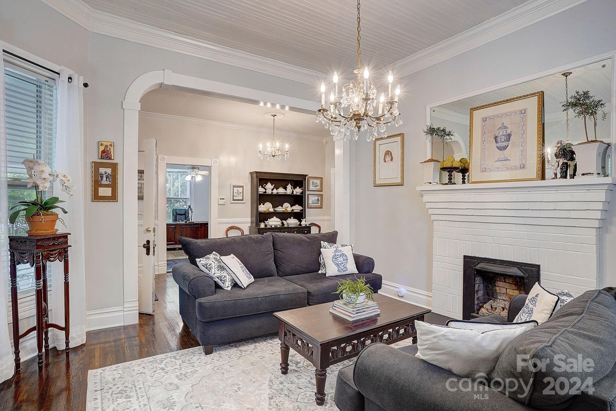 179 Union Street South Concord, NC 28025 - Photo 6 of 38 a living room with furniture a chandelier and a fireplace