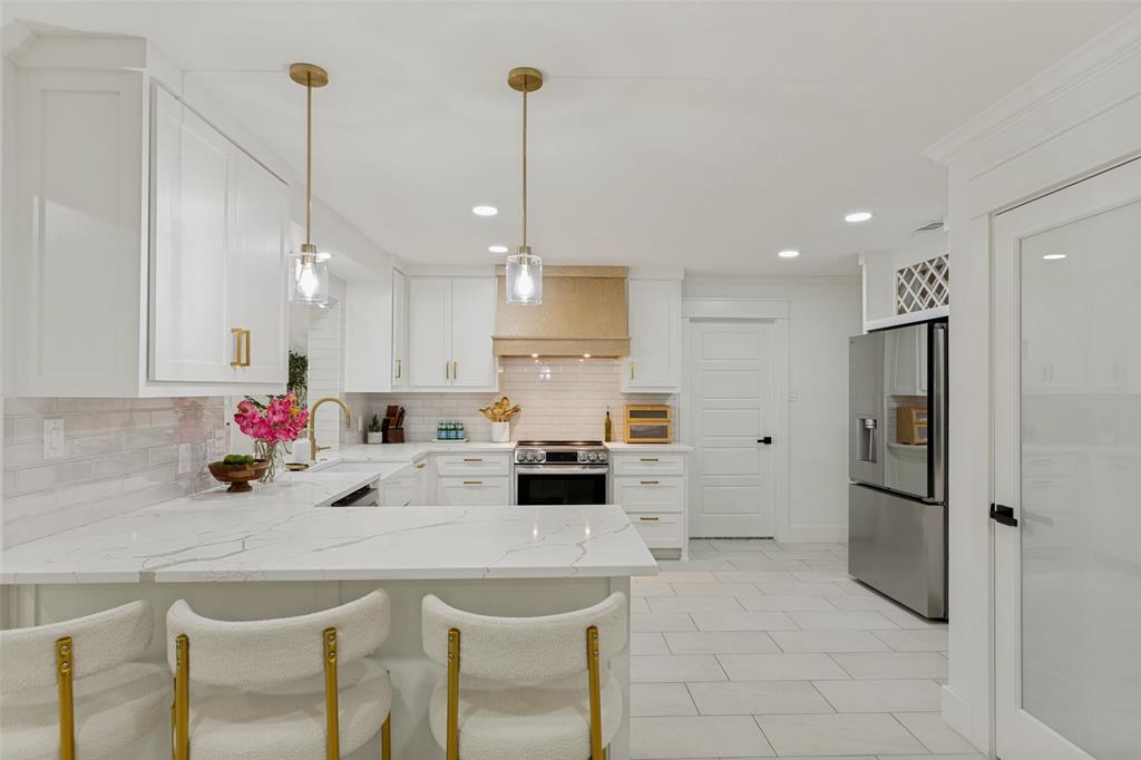 4316 Springbranch Drive Benbrook, TX 76116 - Photo 17 of 39 Kitchen featuring white shaker cabinetry, gold-tone hardware, and pendant lighting