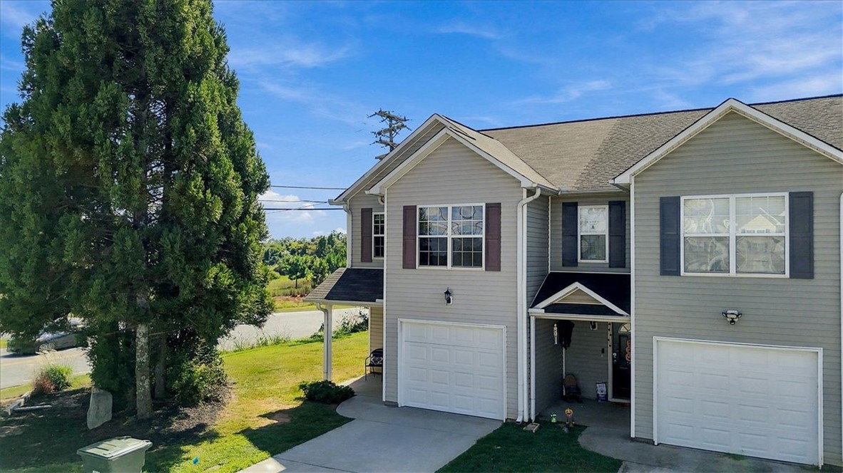 Classic vinyl siding and gabled rooflines define the exterior of this multi-level townhome.