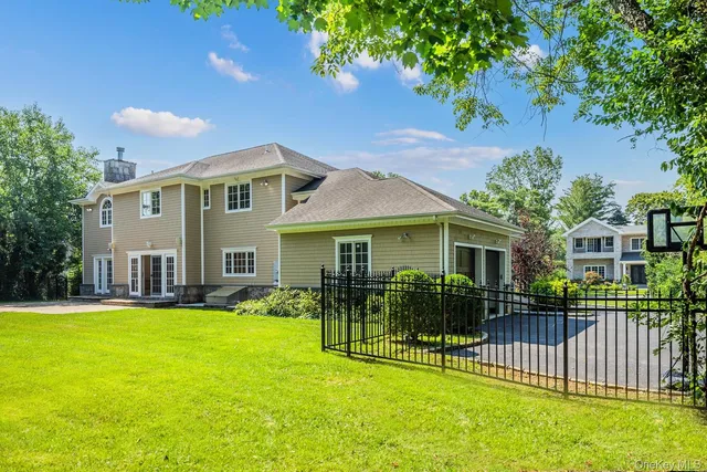 a view of a house with a big yard plants and large trees
