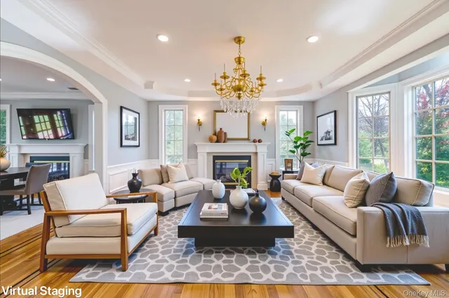 a living room with furniture a chandelier and a fireplace