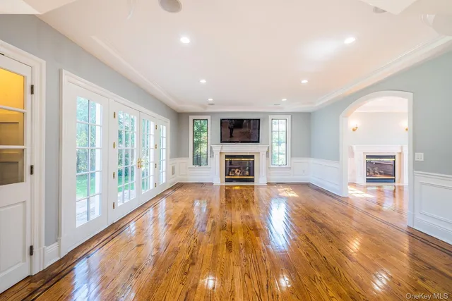 a view of empty room with wooden floor and fireplace