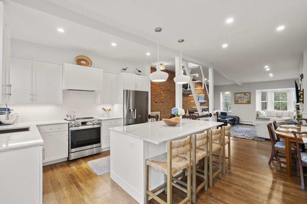 57 Warren Avenue, Unit 3 Boston, MA 02116 - Photo 1 of 24 a kitchen with stainless steel appliances kitchen island granite countertop a stove a sink a refrigerator and chairs
