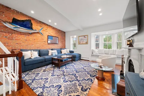 a living room with furniture a large window and a flat screen tv