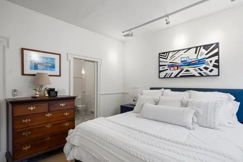 a bedroom with a bed and painting on the wall