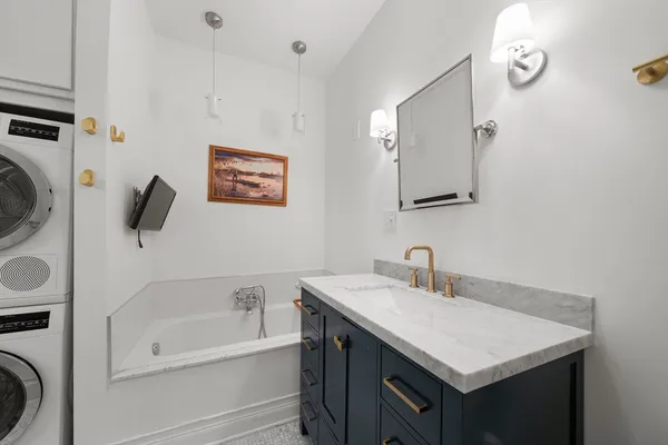 a bathroom with a sink a bathtub and a mirror