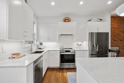 a kitchen with stainless steel appliances granite countertop a sink stove and refrigerator