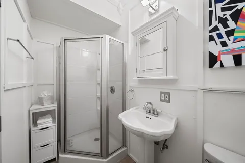 a bathroom with a sink a toilet and shower