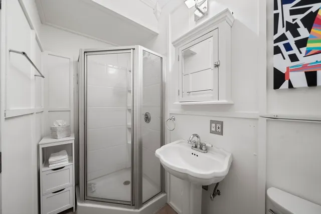 a bathroom with a sink a toilet and shower