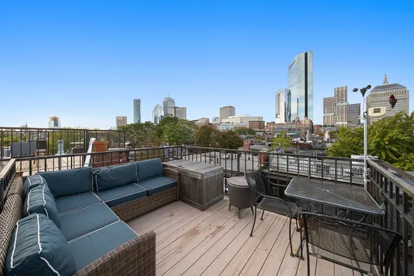 a view of a roof deck with couches and wooden floor