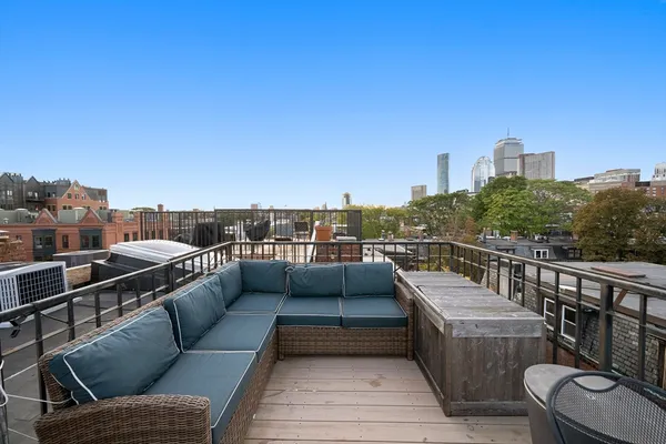 a view of a roof deck with couches and sky view