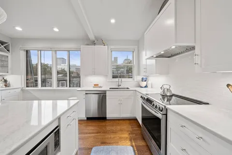 a kitchen with a sink stove top oven and cabinets