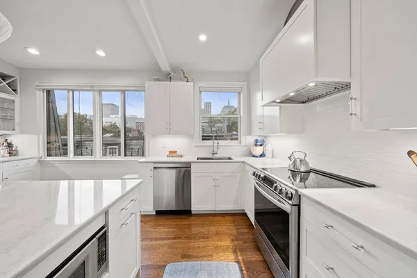 a kitchen with a sink stove top oven and cabinets