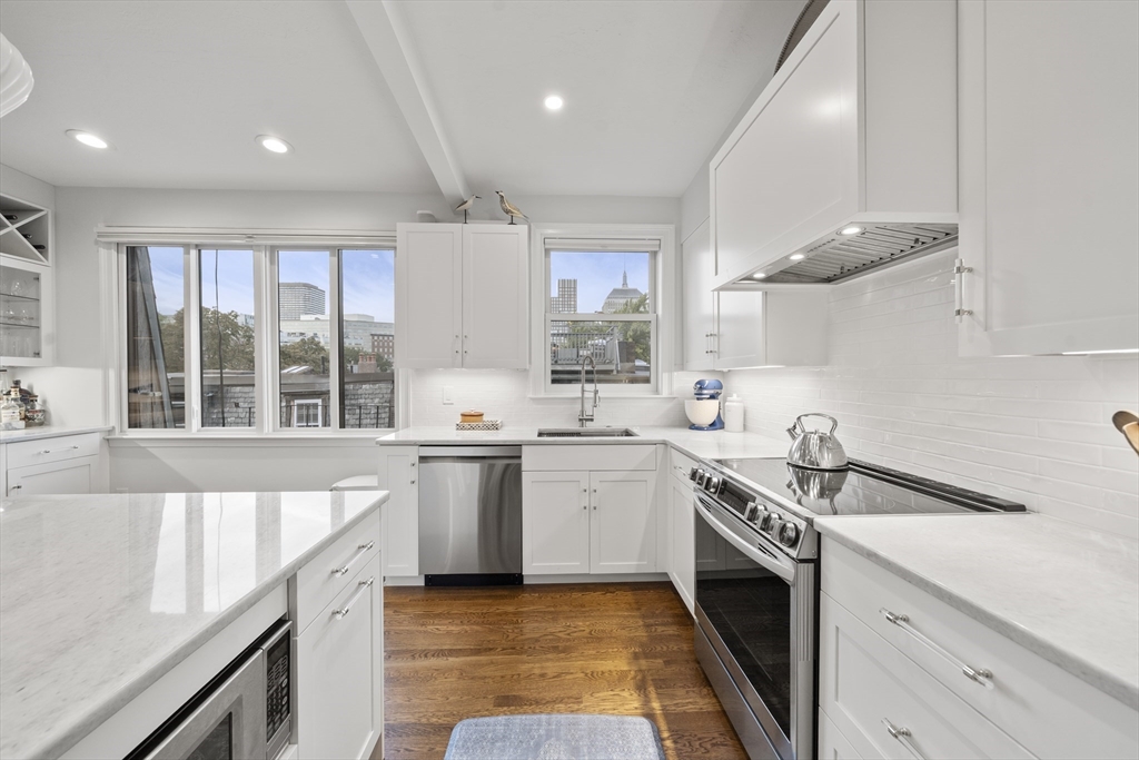 57 Warren Avenue, Unit 3 Boston, MA 02116 - Photo 3 of 24 a kitchen with a sink stove top oven and cabinets