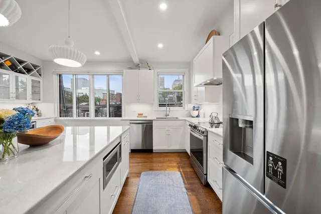 a kitchen with stainless steel appliances a refrigerator sink and stove