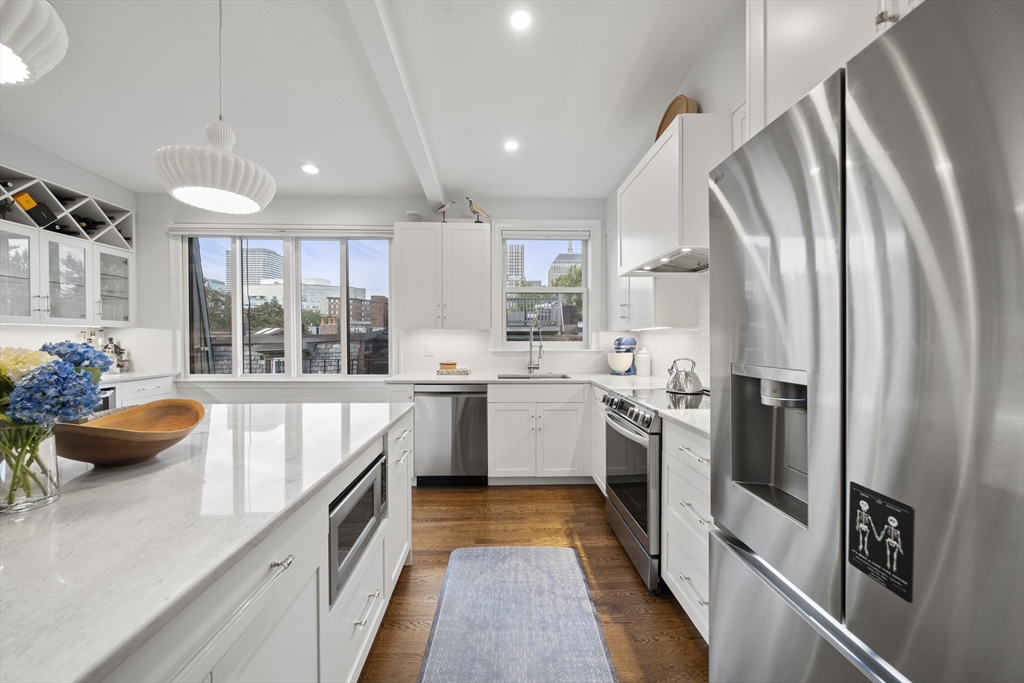 57 Warren Avenue, Unit 3 Boston, MA 02116 - Photo 5 of 24 a kitchen with stainless steel appliances a refrigerator sink and stove