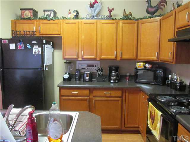 130 Dustin Lane Roxboro, NC 27574 - Photo 2 of 15 a kitchen with granite countertop a refrigerator a stove a sink and a dining table with wooden floor