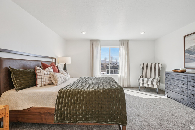 2097 North Ostler Peak Road, Unit 115 Heber City, UT 84032 - Photo 4 of 33 Carpeted bedroom featuring a large window with exterior scenery, recessed lighting, and a dark wood-finish bed frame with a leather headboard